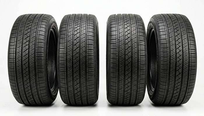 Lineup of high-mileage touring tires on a clean white studio background