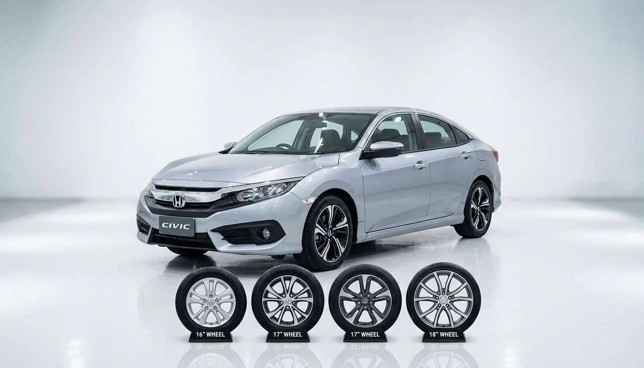 Silver Honda Civic parked indoors with four different sized aftermarket tires lined up in front
