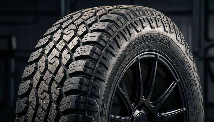 Close-up of a rugged all-terrain Honda Pilot truck tire tread and sidewall on a black wheel rim