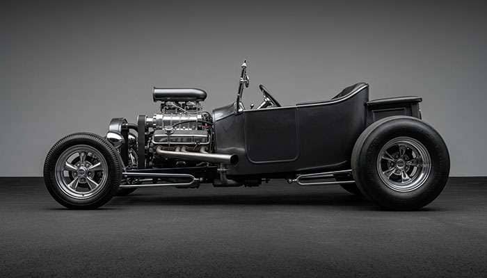 Classic hot rod big-and-little staggered wheel and tire setup showing narrow front wheel with wide rear drag tire