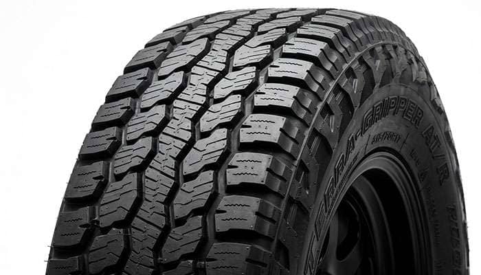 Close-up of a hybrid rugged-terrain tire tread showing tight center blocks and open aggressive shoulders