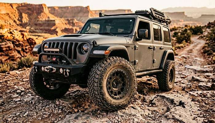Jeep Wrangler with aggressive off-road tires aired down on a rocky trail