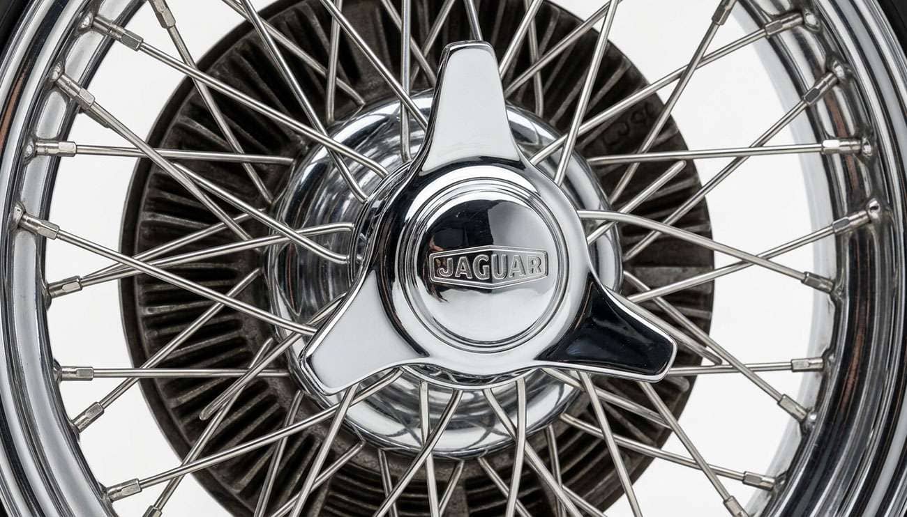Three-eared chrome knockoff spinner on a vintage classic sports car wheel hub