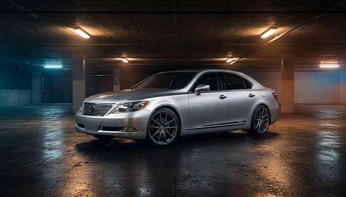 Silver Lexus sedan with custom multi-spoke rims parked in a dimly lit underground garage