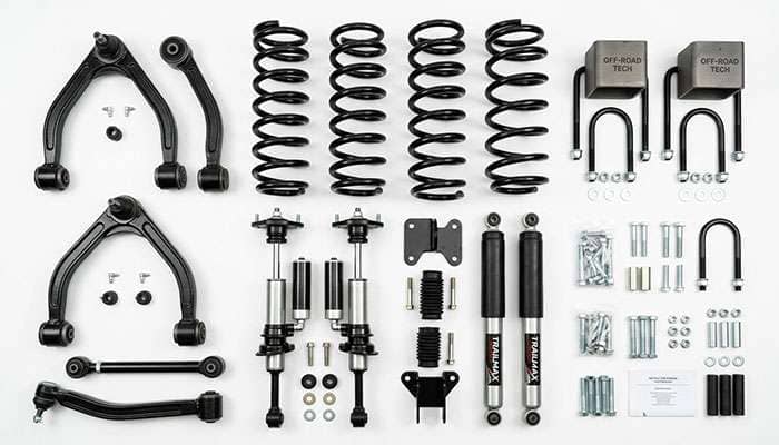 Lift kit suspension components laid out including coil springs shocks control arms and lift blocks