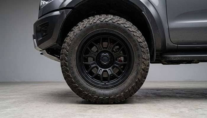 Detail of lifted truck wheel and tire showing negative offset and backspacing relationship to fender