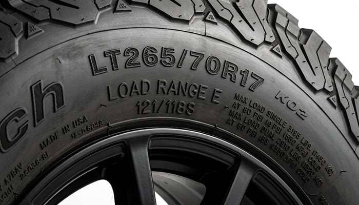 Close-up of a light truck tire sidewall showing the load range letter, load index, and maximum inflation pressure markings