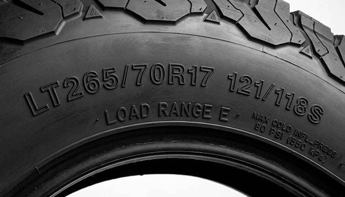 Close-up of light truck tire sidewall markings showing load index, load range letter and maximum cold inflation pressure