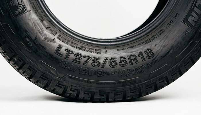 Close-up of an LT275/65R18 light truck tire sidewall showing the load index and load range markings