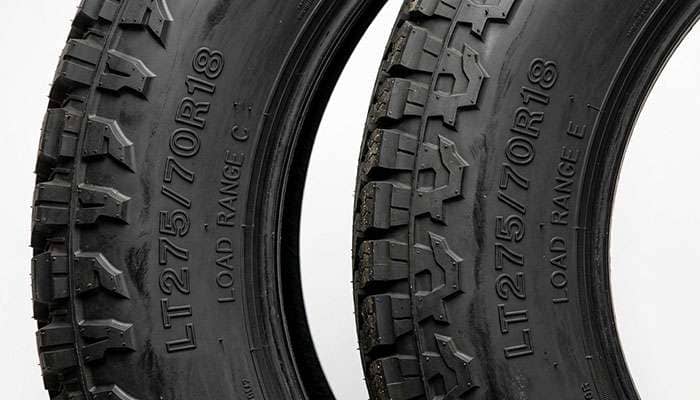 Close-up of LT275/70R18 light truck tire sidewalls comparing Load Range C and Load Range E markings