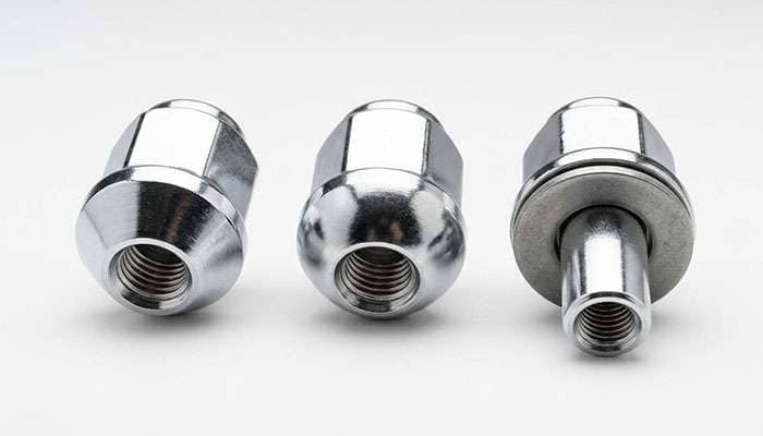 three lug nuts side by side showing a tapered conical seat, a rounded ball seat, and a flat shank mag seat with washer