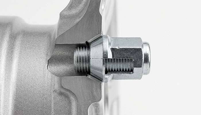 Cutaway view of a conical 60-degree lug nut fully seated inside a tapered wheel lug hole