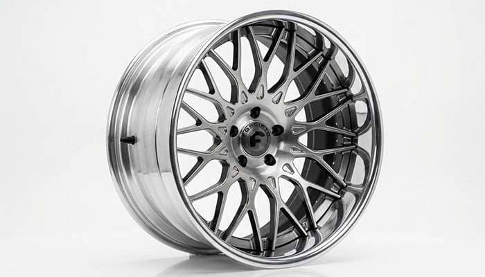 Large-diameter luxury SUV rim with polished mesh finish on a white studio backdrop