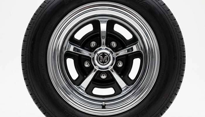 Close-up of a Magnum 500 wheel showing the iconic five-slot design with chrome finish and black inserts
