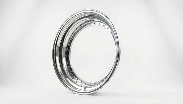 A freshly refinished polished outer barrel lip separated from a 3-piece wheel showing component-level restoration