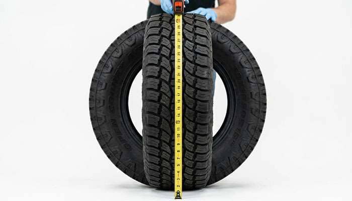 Tape measure checking the overall diameter of a 30-inch all-terrain tire