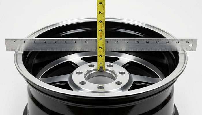 Straightedge and tape measure checking the backspacing of a six-lug truck wheel
