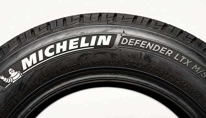 Close up of a Michelin Defender LTX M/S tire sidewall showing the DOT date code and size markings