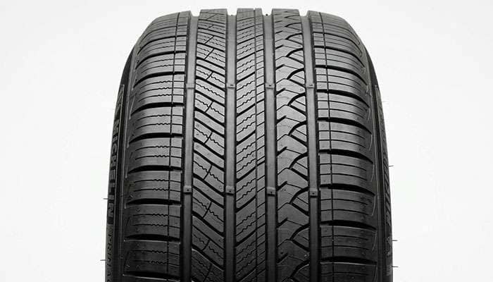 Close up of the asymmetric five rib tread pattern on a Michelin Primacy Tour A/S tire showing shoulder grooves and block chamfers