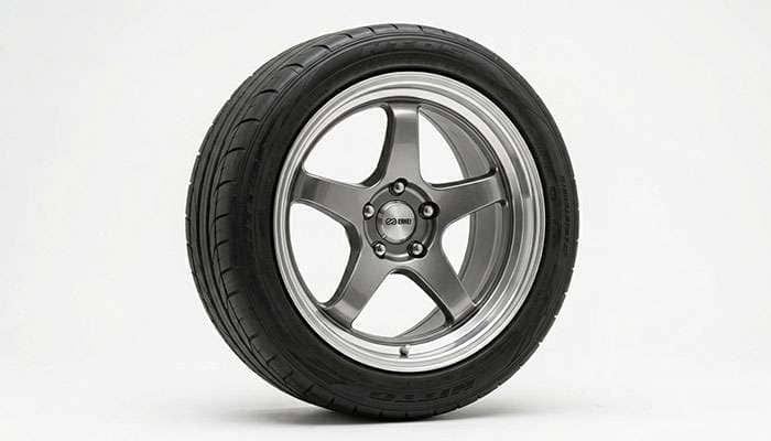 Close-up of a tire mounted on an aftermarket alloy wheel against a clean white studio backdrop