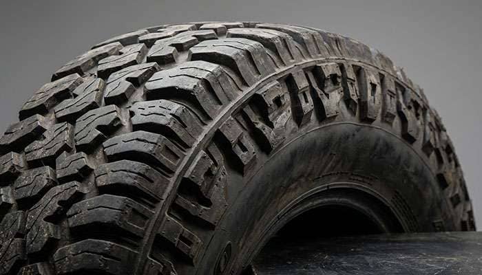 Mud-terrain tire sidewall detail showing 3-ply construction reinforcement layers