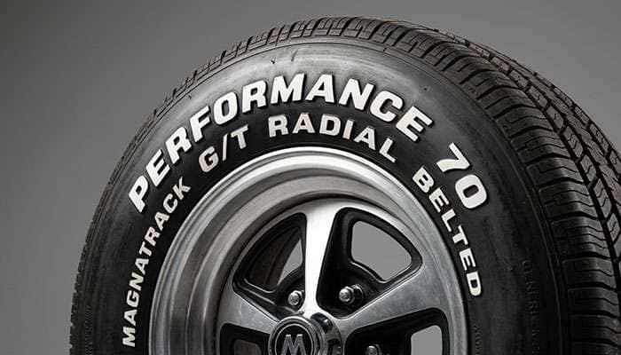 Detail of muscle car tire showing raised white letter sidewall on classic American muscle car aesthetic