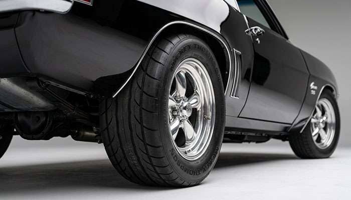 Close-up of a wide rear tire filling the rear fender of a classic Chevelle showing proper staggered fitment