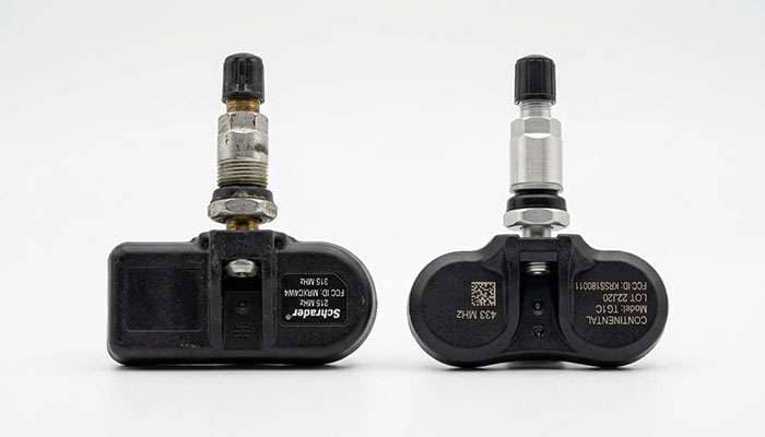 Two tire pressure monitoring sensors side by side, a 315 MHz S550 sensor and a 433 MHz S650 sensor
