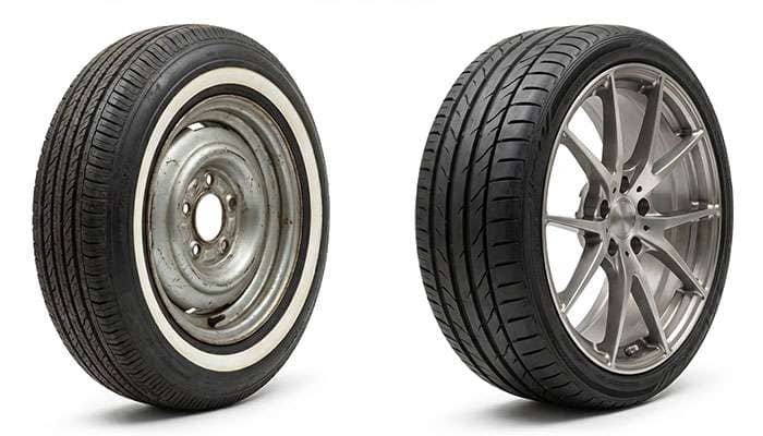 Comparison of an old narrow car wheel with whitewall tire and a modern wide flat car wheel with alloy rim