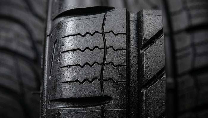 Close-up of new tire tread showing mold release lubricant on tread surface before break-in period