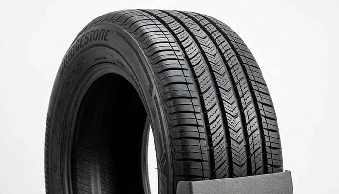 Close-up of a new all-season touring tire tread, an even-wearing replacement for a feathered tire
