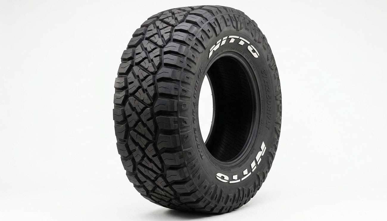 Nitto Ridge Grappler hybrid terrain tire with aggressive sidewall lugs and raised NITTO lettering on a clean white seamless backdrop