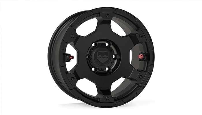 Metallic black Nomad Off-Road Wheel Deluxe 6x139mm by TeraFlex with a five-spoke design and red accents