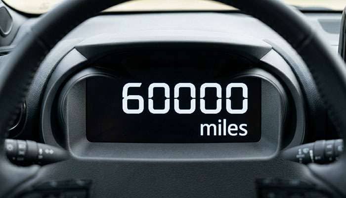 Vehicle odometer closeup showing 60000 miles milestone scheduled maintenance threshold