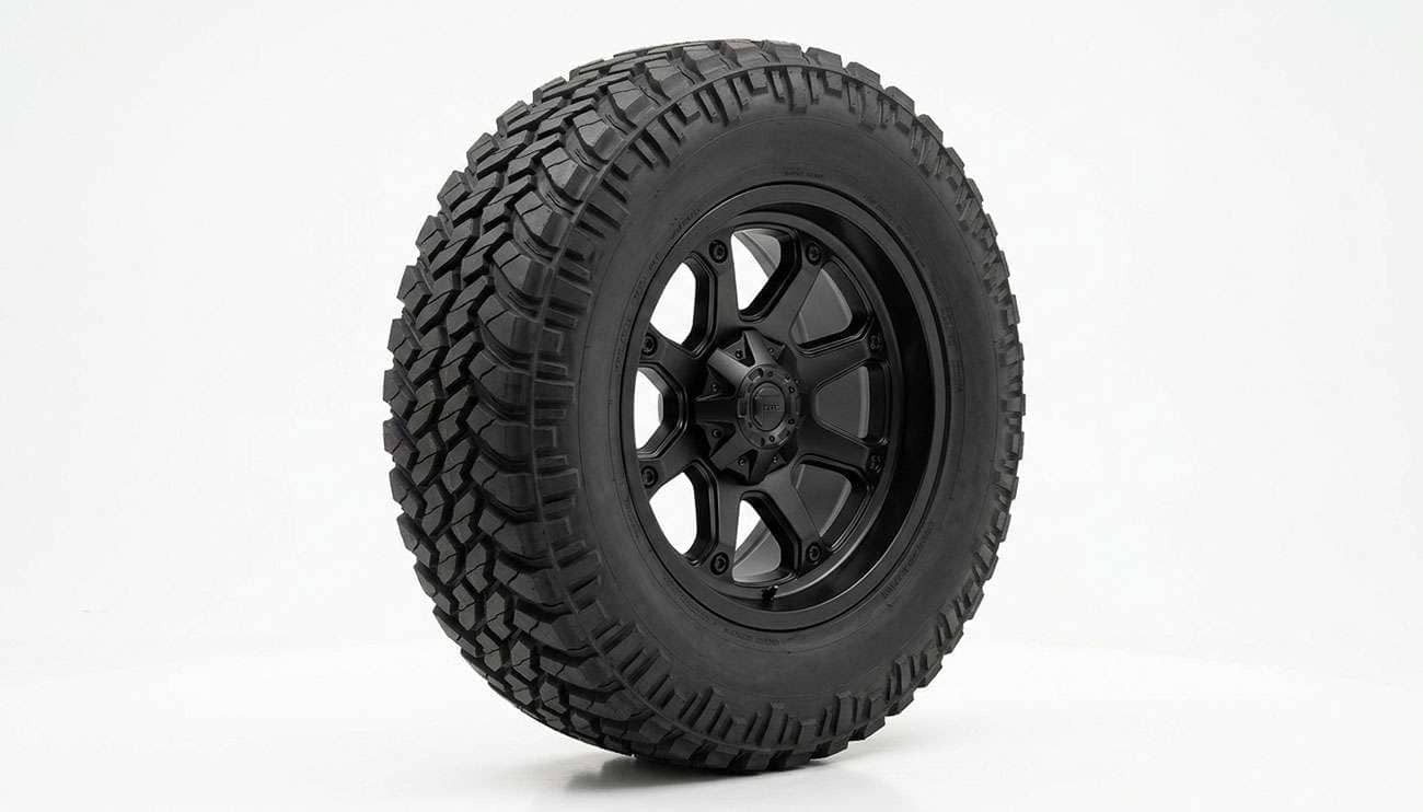 Aggressive off-road wheel mounted with a rugged-terrain tire, three-quarter studio view