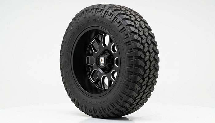 Aggressive off-road mud terrain tire mounted on black aftermarket wheel showing offset and backspacing