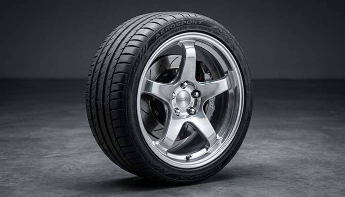 High performance summer tire mounted on a sports car alloy wheel showing aggressive tread design and wide contact patch