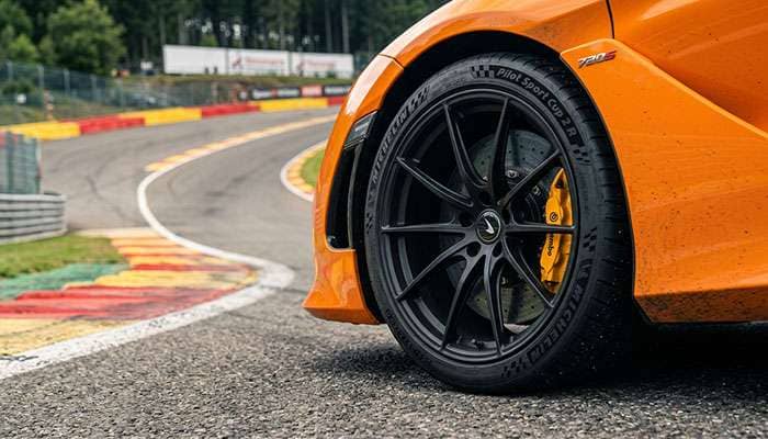 Performance sports car with ultra high performance tires on track showing aggressive tread pattern and sidewall construction