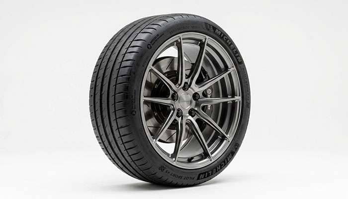 A performance wheel and low-profile tire assembly on a clean white studio backdrop