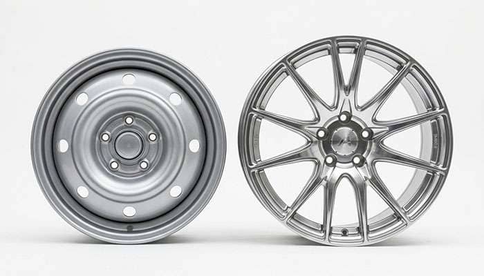 Side-by-side comparison of a small-diameter factory steel wheel and a larger-diameter polished aftermarket alloy wheel
