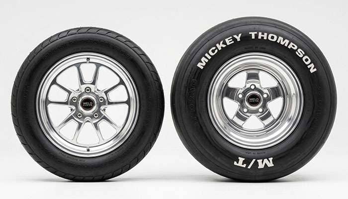 Pro street big-and-little tire pairing with a skinny front runner next to a wide rear drag tire on a clean white studio backdrop