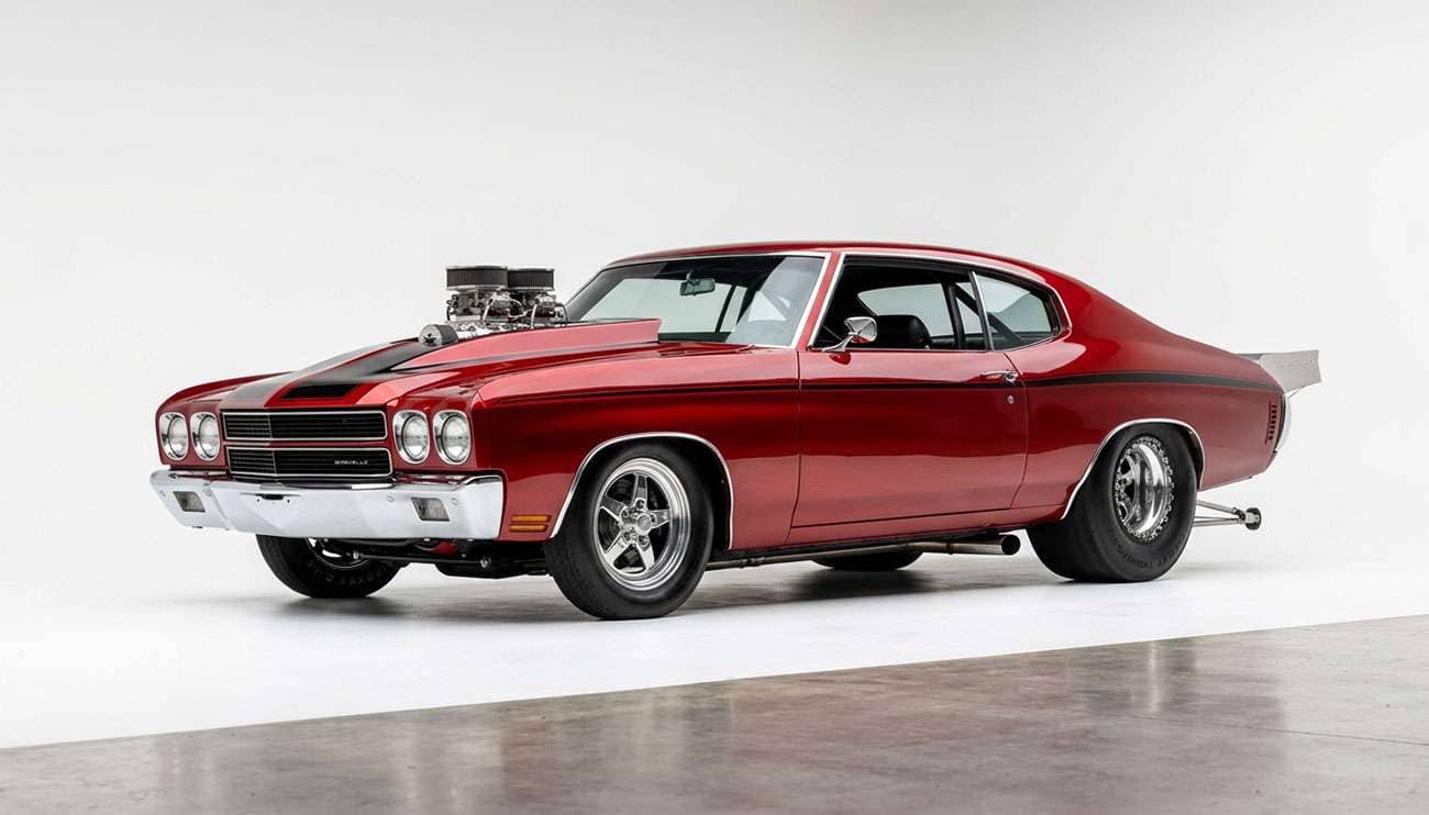 Pro street muscle car with skinny front runner tires and giant tubbed rear drag tires sitting low and wide on a clean white studio backdrop