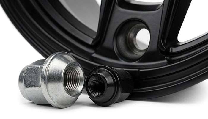 Comparison of a factory bulge acorn lug nut and a small diameter conical seat lug nut for aftermarket wheels