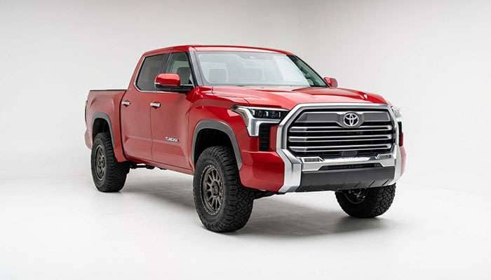 Front and side view of a red 2022 Toyota Tundra pickup truck with large off-road tires against a white background