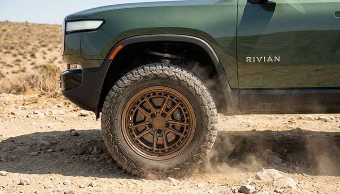 Close-up of a green Rivian R1T with bronze MPP Mega Terra forged wheels and rugged off-road tires