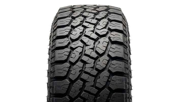 Rugged-terrain hybrid tire tread pattern with aggressive shoulder lugs, studio product view