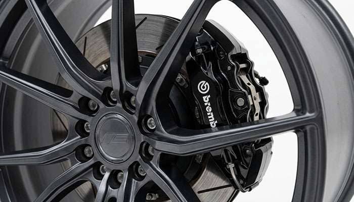 S650 Mustang rear four-piston fixed brake caliper behind a 19-inch wheel spoke