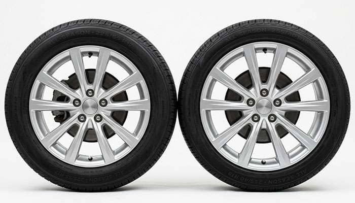 Two tires of identical overall height mounted on 17-inch and 19-inch alloy wheels side by side showing the shorter sidewall on the larger rim
