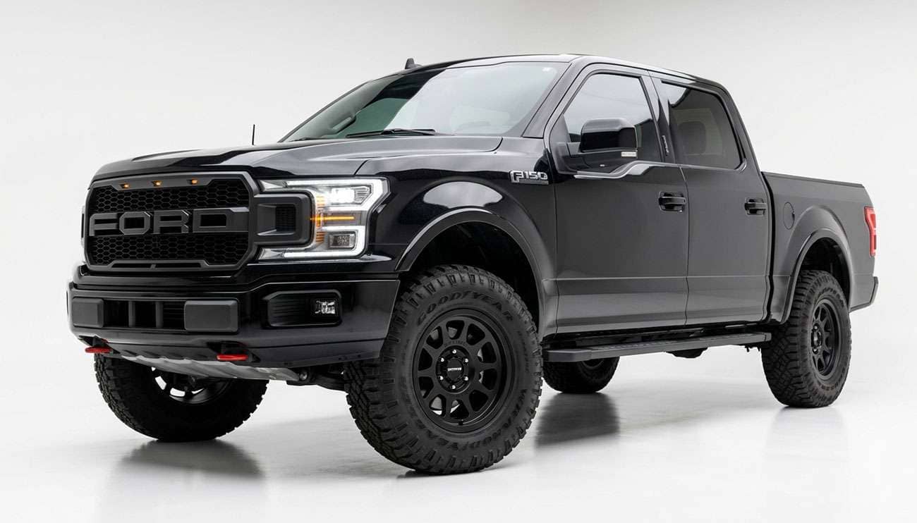 Full-size pickup truck with a leveled front end running 35-inch all-terrain tires on aftermarket wheels