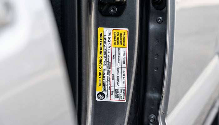 Tire and Loading Information placard on a pickup door jamb showing factory tire size and cold inflation pressure